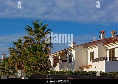 Une ligne de plage des chalets d'été méditerranéen sous ciel bleu. Palmiers et peint dans des maisons blanches aux toits de tuiles. Banque D'Images