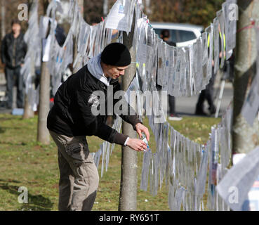 Wiesbaden, Allemagne. 12 mars 2019. Raccrochez le militants 'Leine des Grauens" (laisse des horreurs), une ligne avec imprimé dans les journaux, sur des allégations de crimes de réfugiés. L'affaire contre le demandeur d'asile irakien Ali B. pour le meurtre de Susanna F. de Mayence a été ouverte l'an dernier à Wiesbaden. Plusieurs organisations de droite a tenu une manifestation devant le palais de justice à l'encontre des réfugiés en Allemagne et des sanctions pour les réfugiés. Crédit : Michael Debets/Alamy Live News Banque D'Images