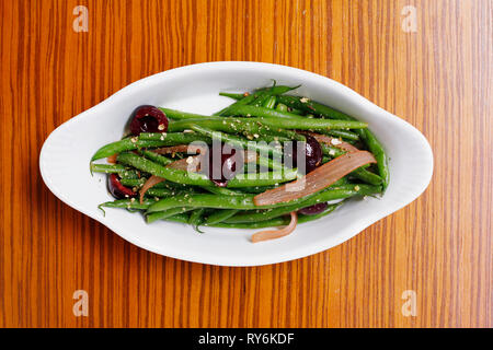 Vue aérienne d'haricots verts aux olives servi dans la plaque sur la table en bois Banque D'Images