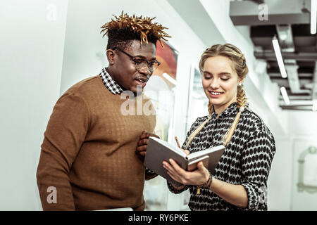 Cheerful young girl ajout de notes à son journal Banque D'Images