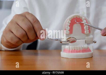 Dentiste à l'aide d'outils à dents modèle dans cabinet dentaire professionnel/ clinique dentaire, soins dentaires et de concept Banque D'Images
