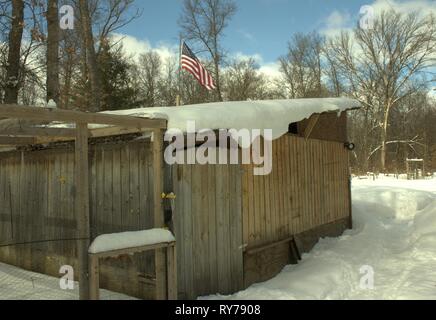 Des gouttes de neige d'un hangar en bois, un jour d'hiver Banque D'Images