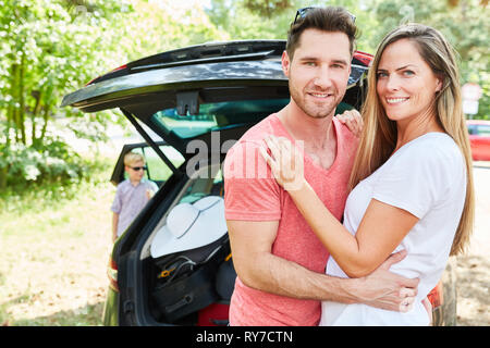 Couple heureux parents est debout en face de la voiture et à l'avant pour les vacances d'été Banque D'Images