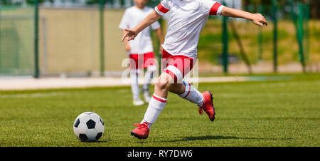 Soccer Shot. Les jeunes garçons Tournoi de soccer Match de football des coups sur le terrain d'herbe. Les joueurs de football Duel. L'exécution de jeunes joueurs de soccer s'école Banque D'Images