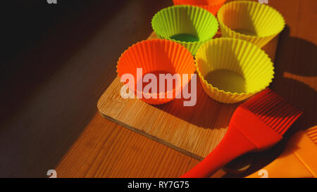 Pinceau en silicone et les écrans de cupcake sur table en bois. Concept de cuisine et cuisine sur fond de bois Banque D'Images