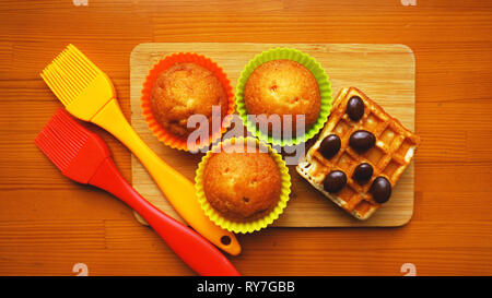 Simple mini muffins en silicone colorés et cuisson des gaufres. Concept de cuisine et cuisine sur fond de bois Banque D'Images