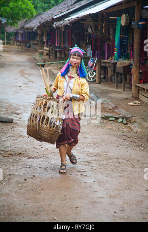 La femme Kayan nettoie la route dans le village Ban Huai Seau Tao Thaïlande NV (Mae Hong Son). La Thaïlande. Banque D'Images