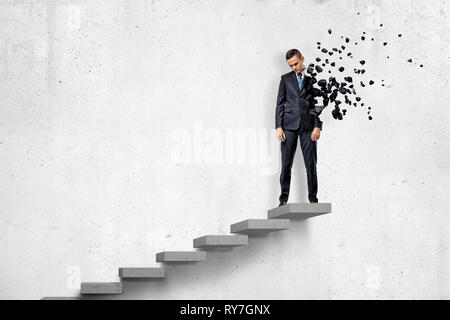 Jeune homme d'égrenage en petits morceaux sur le dessus de l'escalier sur fond blanc Banque D'Images