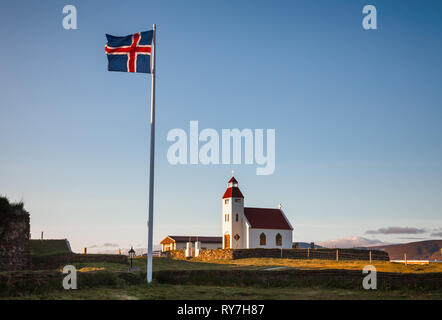Voletant drapeau Islandais près de l'église blanche à Modrudalur ferme, le lieu habité le plus élevé en Islande, Norður-Múlasýsla, l'Est de l'Islande, Scand Banque D'Images