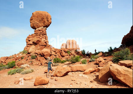 Balades visiteur par Balanced Rock, un célèbre rock formation à Arches National Park, Utah, USA. Banque D'Images