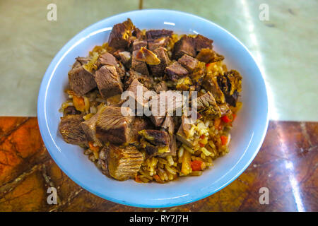 Kygryzstani Pilaf d'agneau traditionnel avec d'énormes morceaux de viande sur le riz dans un bol Banque D'Images