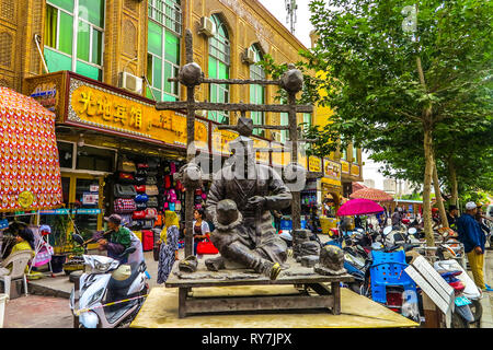 La vieille ville de Kashgar Bazar Ouïghour Market Street Statue homme chapeaux traditionnels de fabrication Doppa Banque D'Images