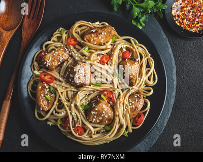Nouilles asiatiques avec poulet Teriyaki sésame , rustique en pierre, arrière-plan. Libre. Nouilles Japonais/Chinois Banque D'Images