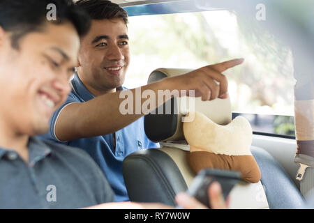 Deux beau mâle ami ou client direction de pointage à l'intérieur de discuter de quelque chose lookingor voiture Banque D'Images