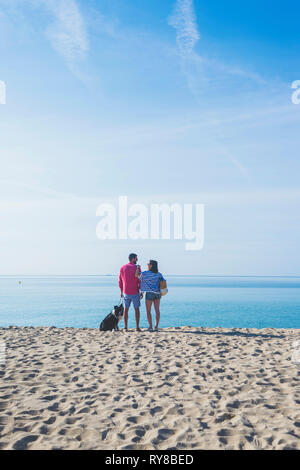 Vue arrière du couple avec chien à la sky Banque D'Images