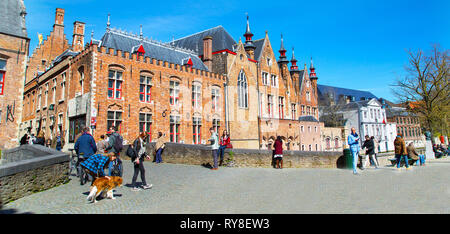 Bruges, Belgique - 10 Avril 2016 : Les gens en centre ville et colorés des maisons traditionnelles à Bruges, Belgique contre le ciel bleu Banque D'Images