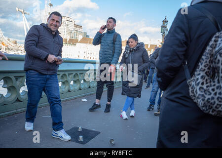 Des groupes bien organisés les touristes tentent de jouer et de passer leurs vacances en espèces à un jeu de ballon sur le pont de Westminster, Londres, Royaume-Uni. Banque D'Images