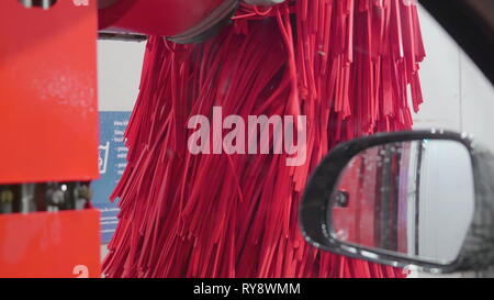 Le gros pinceau rouge sur le côté après avoir laver la voiture à l'intérieur de la station de lavage Banque D'Images