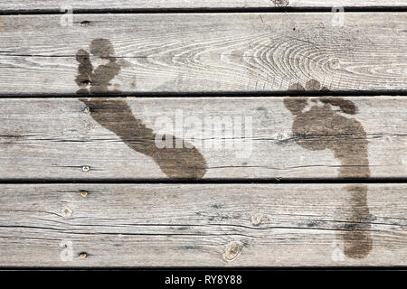 Empreintes humides sur une jetée en bois / pont. Concept pour la natation / baignoire / Location, vacances d'été, l'amusement au soleil, etc. Fullscreen texture. Banque D'Images