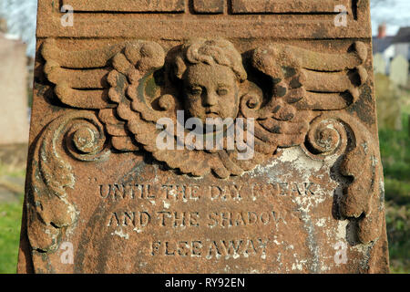 Plaque sculptée et chérubin sur une croix celtique dans le cimetière de l'église Saint Augustin, Penarth, dans le sud du Pays de Galles, Royaume-Uni. Banque D'Images