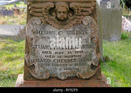 Plaque sculptée et chérubin sur une croix celtique dans le cimetière de l'église Saint Augustin, Penarth, dans le sud du Pays de Galles, Royaume-Uni. Banque D'Images