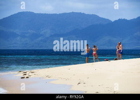 Des couples européens du tourisme de prendre des vacances photos sur plage de sable blanc - Île Linapacan, Palawan - Philippines Banque D'Images