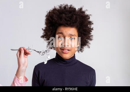 Garçon aux cheveux noirs bouclés à la situation de confusion Banque D'Images