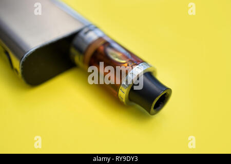 Vape metal stylo cigarette électronique avec vaping fond jaune Banque D'Images