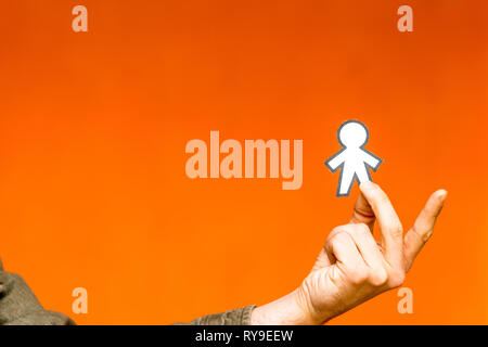 Heureux guy montrant silhouette pour papier April Fools Day orange sur fond flou Banque D'Images