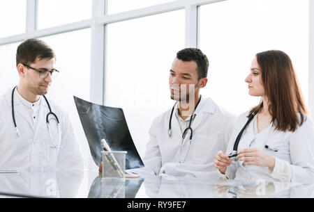 Collègues médecins discuter de x-ray, assis à la table de bureau Banque D'Images