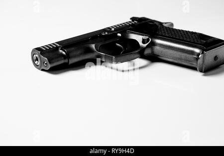 Black metal pistol se trouve sur un fond blanc, close-up Banque D'Images