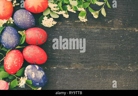 Les oeufs de Pâques colorés sur un fond de bois foncé Banque D'Images