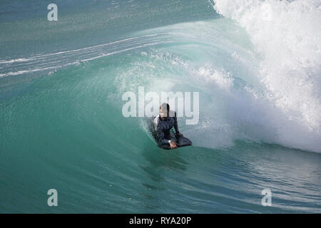 Surfer la crête d'une vague sur un océan bleu azur Banque D'Images