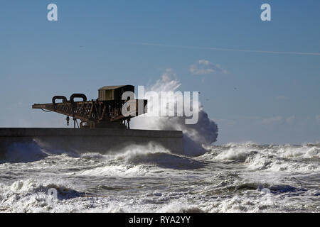 Grosse Vague contre l'ancienne grue et mur nord de Leixoes Port dans le cadre d'une journée ensoleillée, la plage Leca da Palmeira, Porto, Portugal Banque D'Images