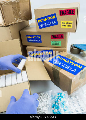 L'aide humanitaire, de l'infirmière en plaçant des boîtes avec des médicaments pour envoyer le Venezuela, conceptual image Banque D'Images