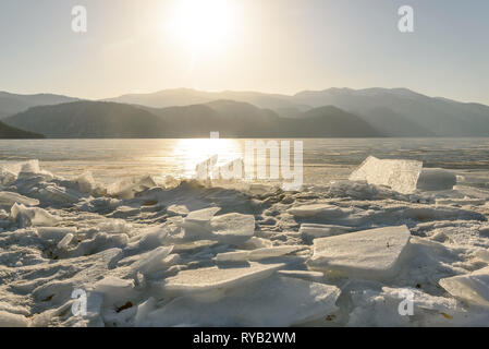 Belle vue sur lac gelé Teletskoye avec de la glace, et le soleil sur les montagnes sur un matin ensoleillé Banque D'Images