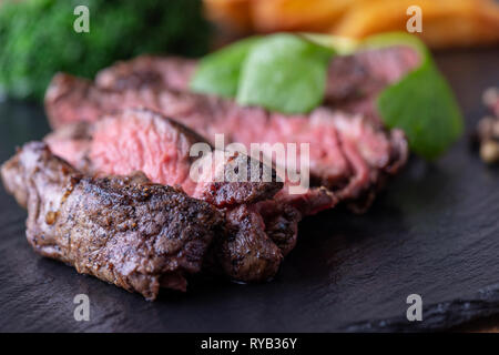 Tranches d'un steak grillé sur ardoise Banque D'Images