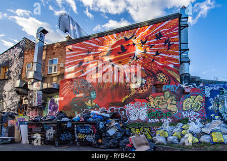 Graffiti sur mur et poubelles et sacs. Pedley Street, près de Brick Lane, London. Banque D'Images