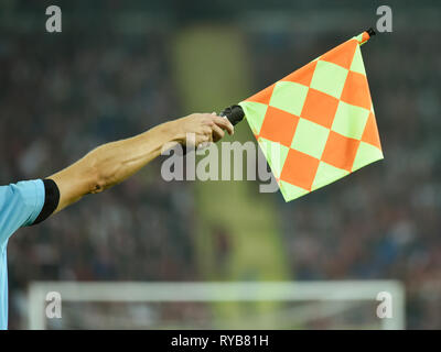 Main levée avec le drapeau de l'arbitre de soccer assistant Banque D'Images