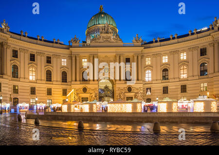 La Hofburg, le palais impérial des Habsbourg, à partir de la Michaelerplatz avec un marché de Noël, à la brunante, Vienne, Autriche. Banque D'Images