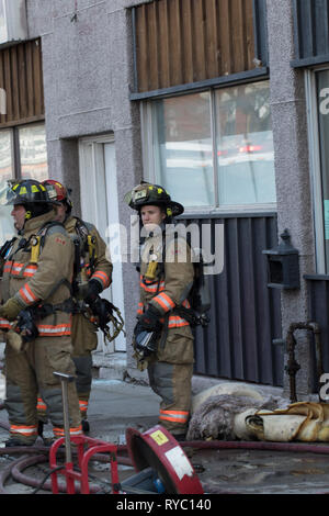 Hamilton, Canada 2019 : Portrait des pompiers portant des respirateurs et des réservoirs d'air frais lors de la réponse à un incendie du bâtiment. Service d'incendie de la ville Banque D'Images