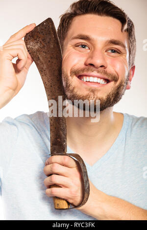 Jeune homme avec le rasage s'amusant avec machette grand couteau. Beau gars dépose face cheveux barbe. Hygiène et soins de la peau l'humour. Banque D'Images