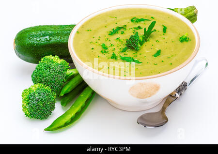 Close-up of Delicious crème de légumes verts (petits pois, brocolis et courgettes) dans un bol. Avant-plan. Isolé sur fond blanc. Banque D'Images