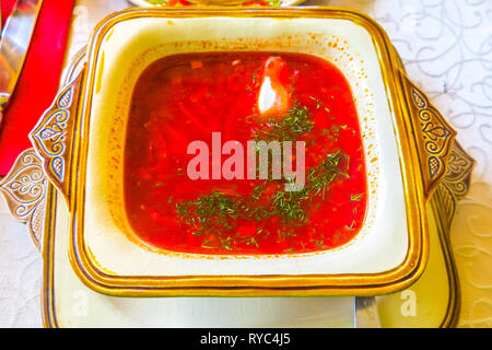 Couleur rouge traditionnelle ukrainienne bortsch soupe avec la crème et l'aneth haché hachée Banque D'Images