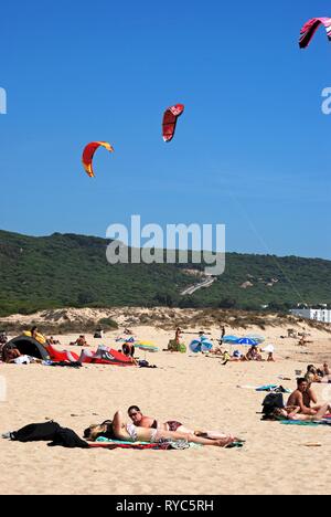 CABO TRAFALGAR, ESPAGNE - 14 septembre 2008 - Les touristes à prendre le soleil sur la plage de surf kites contre le ciel bleu, Cabo Trafalgar, Cadiz Province, Banque D'Images