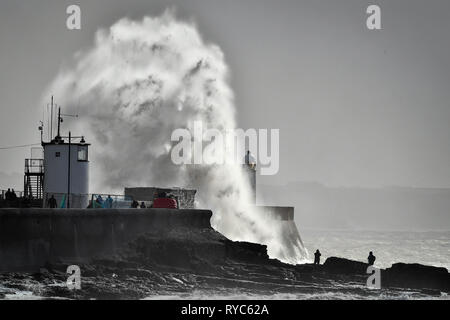 Des vagues énormes gifle contre le mur du port en tant que spectateurs regarder des roches dans la mer à Porthcawl, Pays de Galles, où de fortes pluies et des vents violents ont causé une interruption de voyage dans plusieurs régions du Royaume-Uni que Storm Gareth va vers l'Est. Banque D'Images