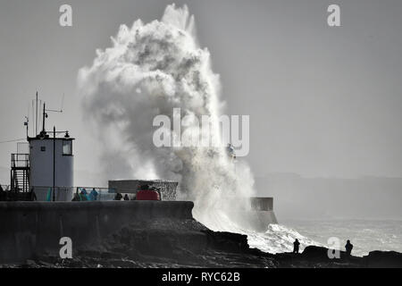 Des vagues énormes gifle contre le mur du port en tant que spectateurs regarder des roches dans la mer à Porthcawl, Pays de Galles, où de fortes pluies et des vents violents ont causé une interruption de voyage dans plusieurs régions du Royaume-Uni que Storm Gareth va vers l'Est. Banque D'Images