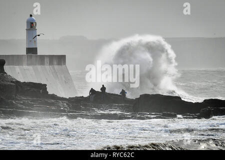 Des vagues énormes gifle contre le mur du port en tant que spectateurs regarder des roches dans la mer à Porthcawl, Pays de Galles, où de fortes pluies et des vents violents ont causé une interruption de voyage dans plusieurs régions du Royaume-Uni que Storm Gareth va vers l'Est. Banque D'Images