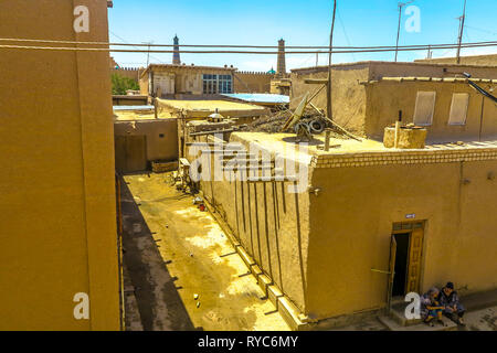 La vieille ville de Khiva allée commune des rues et l'architecture traditionnelle Appartement Résidentiel Accueil Maisons avec deux femmes ouzbeks assis et parler Banque D'Images