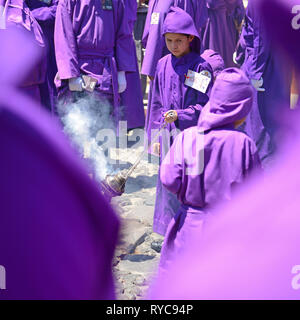 Jeune garçon avec de l'encens pendant la procession de l'cucuruchos en Antigua à Pâques le Vendredi saint, au Guatemala. Banque D'Images